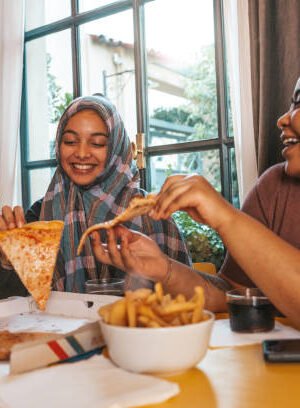 Multicultural friends spending happy time together eating take out food.